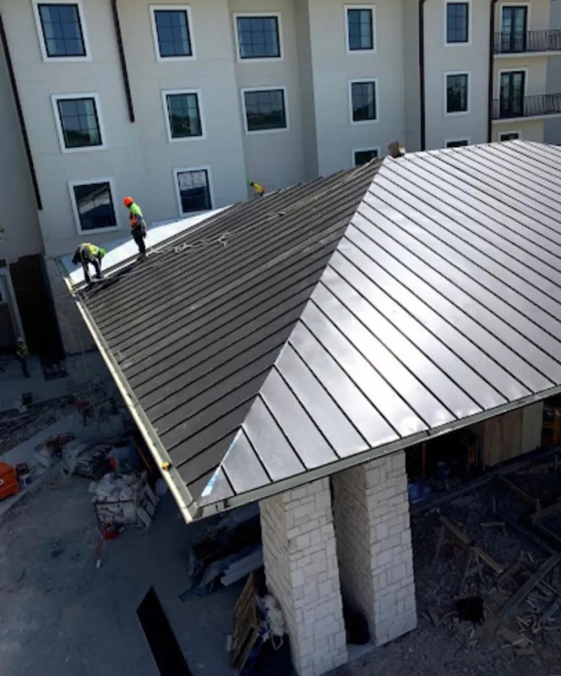 Crew installing standing seam metal roof panels on a commercial project in Canyon Lake